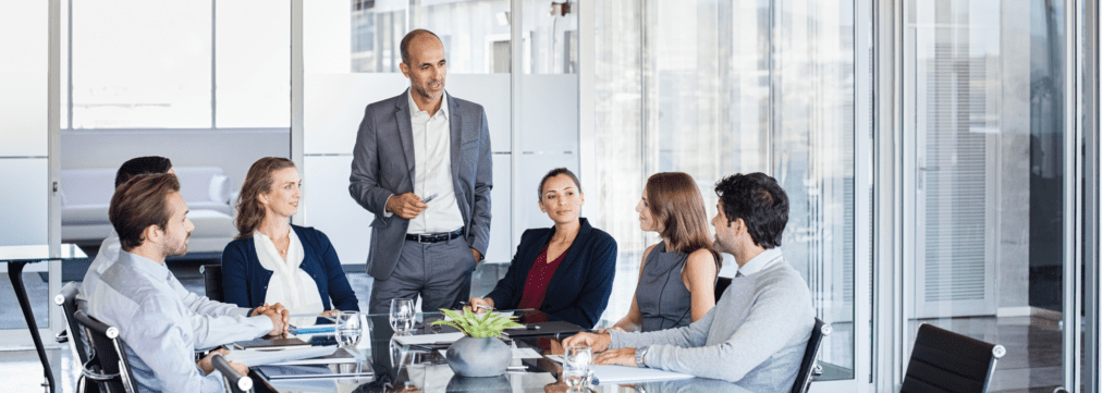 a group of senior office workers having a meeting about product management roles in the fintech space